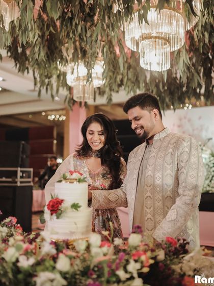 A sweet moment captured as the couple cuts their engagement cake, surrounded by a beautiful arrangement of flowers.