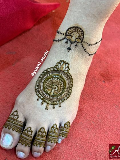 A beautiful bridal foot design featuring a round peacock mandala and a matching peacock anklet.