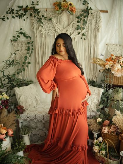 A confident and beautiful solo portrait. The mother-to-be's pose highlights her baby bump, and the rich color of the gown makes the image pop.