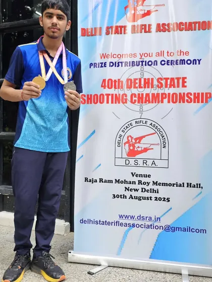 A young shooter showing off his gold and silver medals from the Delhi State Championship. The future is bright.