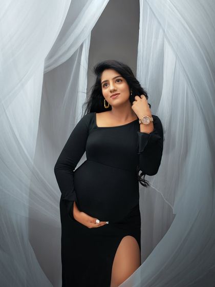 The movement in her hair and the soft fabric create a dynamic and beautiful portrait. This shot highlights the elegance and grace of the mom to be.