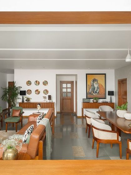 A view into the open-plan living and dining area, framed by a custom wooden archway. The design maintains a cohesive feel, using teak wood accents and a consistent color palette to unite the different zones.