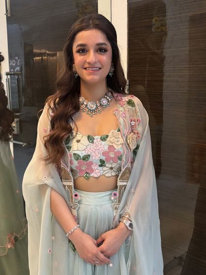 The full look, showing how the soft hairstyle complements the client's beautiful floral outfit. It's a perfect example of a fresh and modern ethnic look.