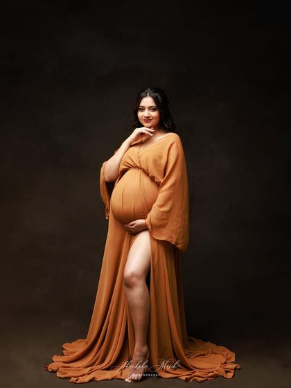 The unique sleeve design and deep mustard color of this gown make for a striking and fashionable maternity portrait.