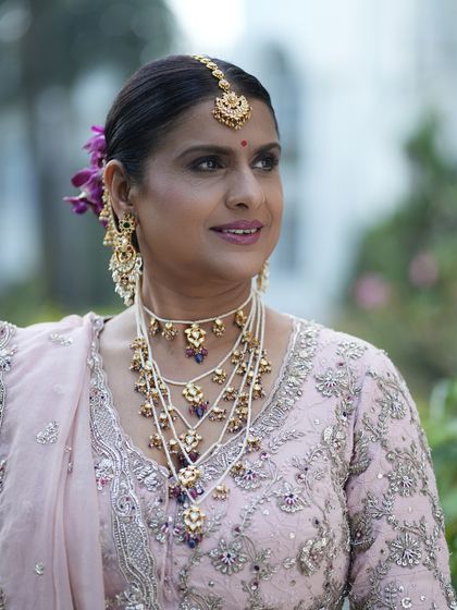 A lovely three-quarter profile. The makeup is soft and flattering, with a focus on creating a smooth, flawless complexion.