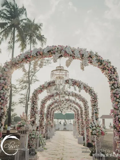 This is what I mean by making an entrance. I designed this breathtaking floral tunnel with cascading blooms and elegant chandeliers to create a truly magical pathway for the couple and their guests at a stunning resort wedding.