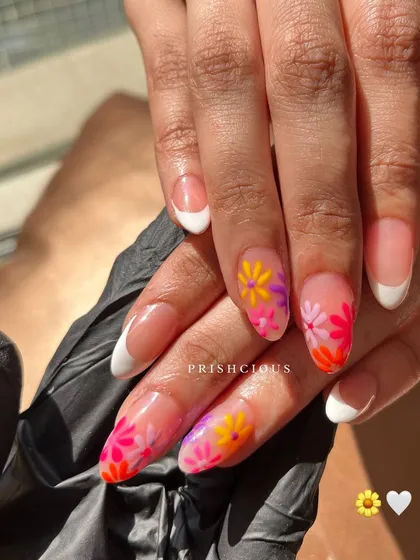 A sunny and cheerful set combining a classic white French manicure with accent nails featuring bright, hand-painted blooming flowers.