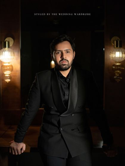 A solo portrait of the groom, his all-black tuxedo a nod to the timeless style of icons like Dev Anand.