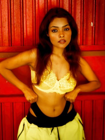 A bold and striking portrait against a vibrant red door. The color contrast is powerful, and her direct gaze is full of attitude.