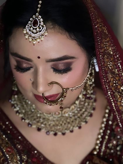 This bride looks so graceful and beautiful. The makeup features a smokey brown eye and a deep maroon lip, perfect for her velvet lehenga.
