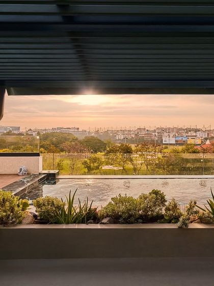 The view from the terrace at sunset, overlooking the Bangalore cityscape. We designed this outdoor space to be a tranquil escape, connecting the home with its wider environment.