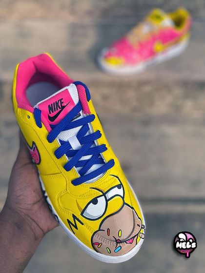 A full view of our Homer Simpson themed Nike sneaker. The bright yellow shoe features Homer eating a donut, with his classic "WOOHOO" quote on the side.