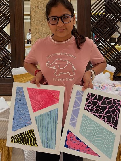 A teen student showing off the two different texture paintings she completed in our workshop.