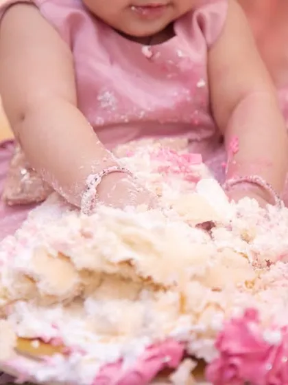 It's not a party until there's cake everywhere. This close-up shot captures the delightful mess of a first birthday cake smash.