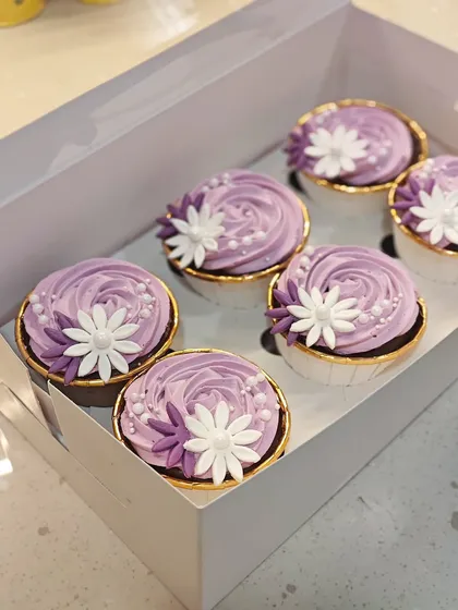 I'm obsessed with making these elegant floral cupcakes. This box features a beautiful lavender frosting with delicate white and purple sugar flowers, perfect for a bridal shower or any special celebration. The flavor inside was dark chocolate with salted caramel.