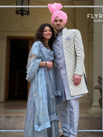 Draped in elegance and tradition, this couple shines in their coordinated light blue outfits at a vibrant Indian wedding.