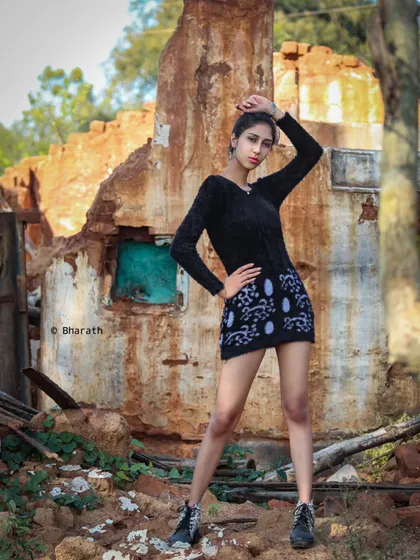 A powerful, full-body pose that emphasizes the fashion-forward styling against the unconventional backdrop.