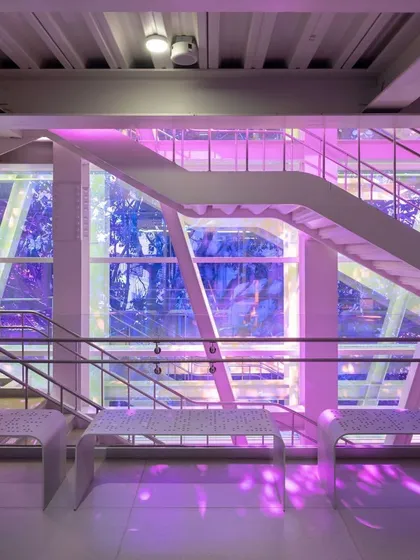 The central staircase at the Museum of Art and Photography (MAP) in Bengaluru, where dichroic film on the glass facade bathes the space in shifting colors. This element turns a simple circulation area into a dynamic experience of light, reflecting our belief that even functional parts of a building can be joyful and inspiring.