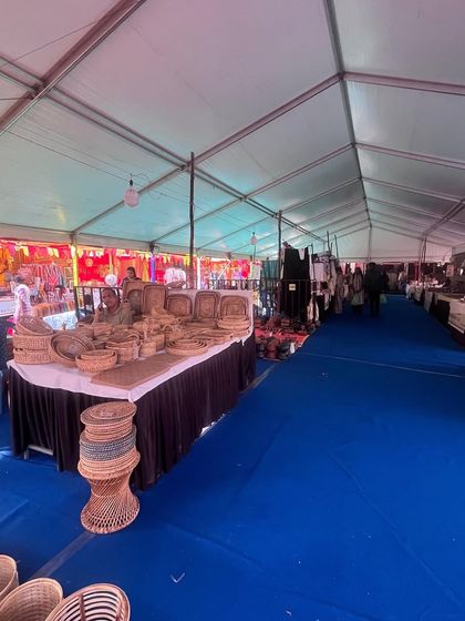 A wide view inside one of the large German Hangar tents used for the Dastkar Bazaar. The blue carpeted aisle and neatly arranged stalls demonstrate the clean and spacious layout I provide for large-scale exhibitions.