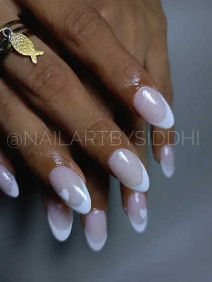 A close-up of the heart detail on this modern French manicure.