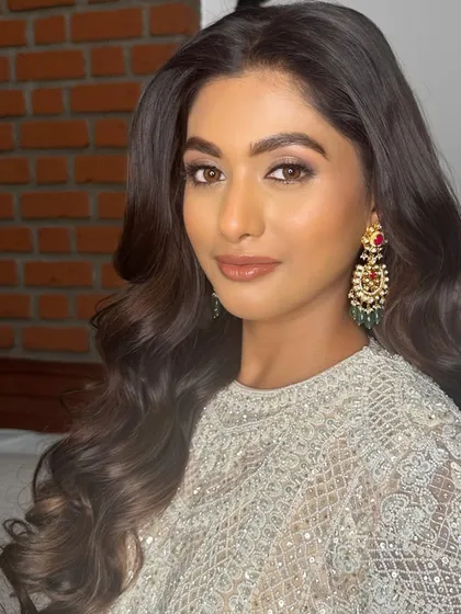 Exuding pure glamour for her reception. This look features a bronzed, smokey eye and a glossy nude lip, paired with voluminous waves.