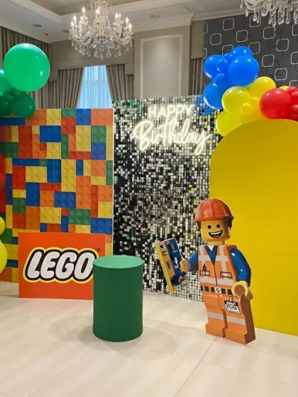 The complete LEGO party setup before the guests arrived. The primary colors, giant block wall, and Emmet character cutout all contribute to the fun and playful theme.