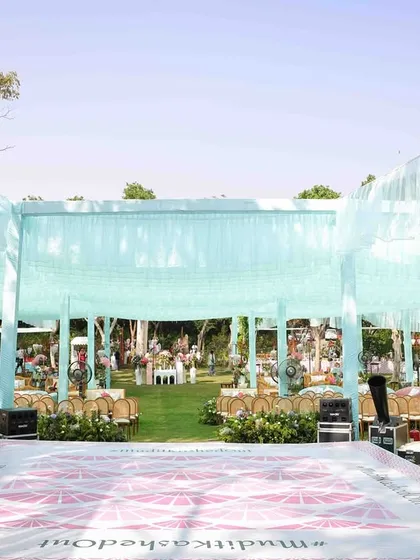 The dance floor and stage setup for the 'Whispers of the Orient' carnival. The light blue draping overhead created a dreamy, airy feel, contrasting beautifully with the lush green surroundings.