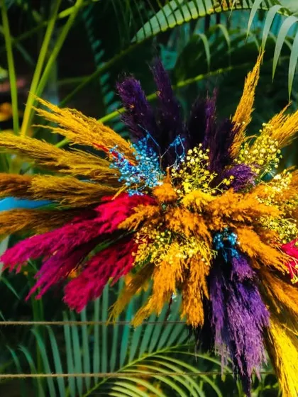 A vibrant floral bunch made of dyed pampas grass, used as a decorative element to bring color and texture throughout the event space.