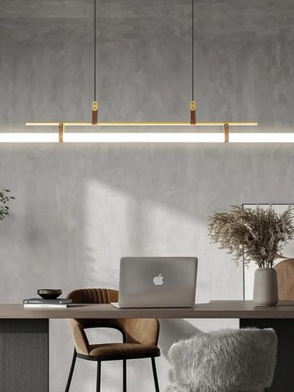 A linear suspension light with leather strap details. This fixture is perfect for hanging over a desk or conference table, adding a touch of rustic modern style.