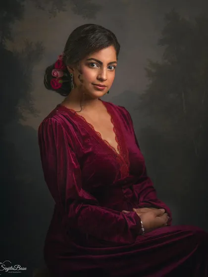 Inspired by the Grand Manner era of portraiture, this image combines a classic pose with a painted landscape backdrop. Divya's velvet dress and the soft, directional light create a vintage, romantic feel, transforming a simple portrait into a timeless piece of art.