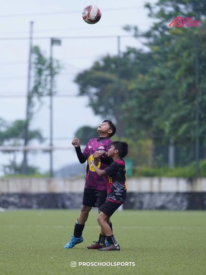 An aerial duel for the ball, showcasing the players' commitment in all conditions.