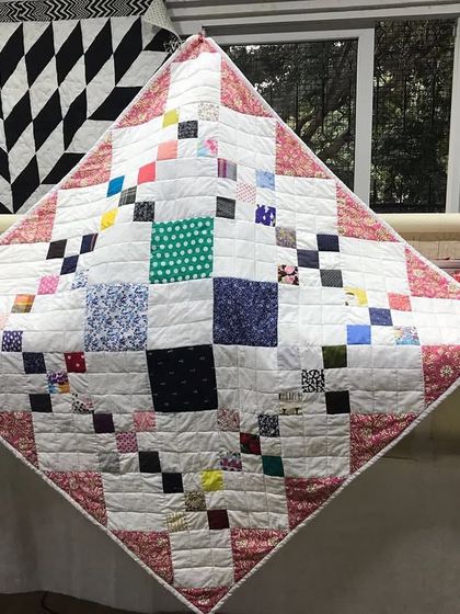 A scrappy patchwork quilt laid out on the longarm machine, ready for quilting.