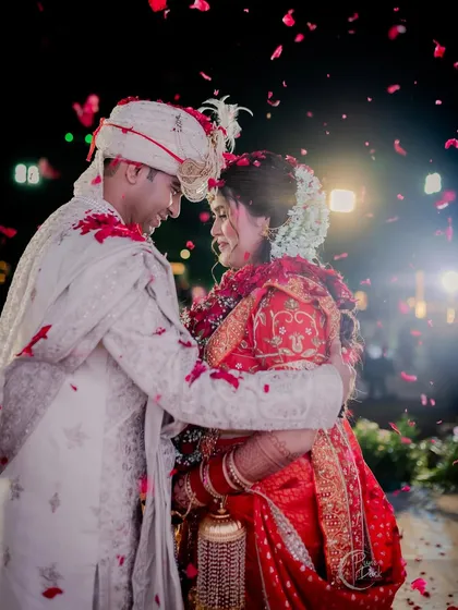 A magical moment of the couple under a shower of rose petals. The bride's joy is palpable.