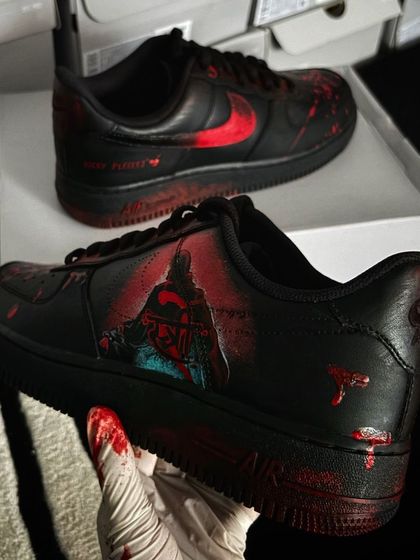 A pair of black Nike Air Force 1s customized for the horror-comedy movie "Stree 2," featuring spooky, blood-splatter effects.