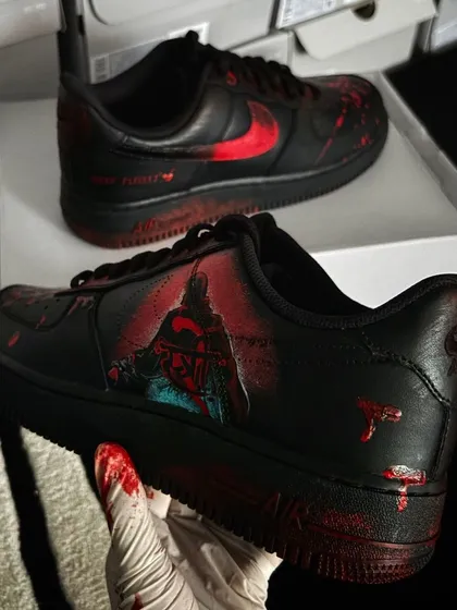 A pair of black Nike Air Force 1s customized for the horror-comedy movie "Stree 2," featuring spooky, blood-splatter effects.