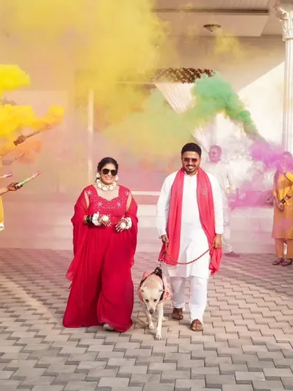 A grand entrance with color bombs and a furry friend. I love capturing unique and personal touches that make your Haldi ceremony special.