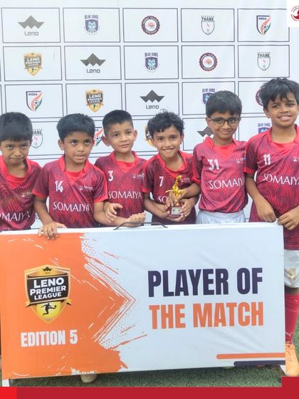 The young champions of the Somaiya FC U-8 team pose with the Player of the Match trophy after a win in the Leno Premier League.