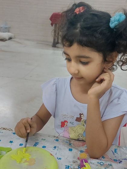 Listening is key. A candid moment of a student deeply engaged in her painting, a reminder that a teacher's role is to guide and be present for their students.