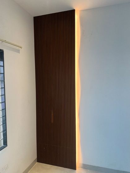 A detail shot of a fluted wood panel with integrated backlighting. This technique adds depth, texture, and a warm ambient glow to any wall.