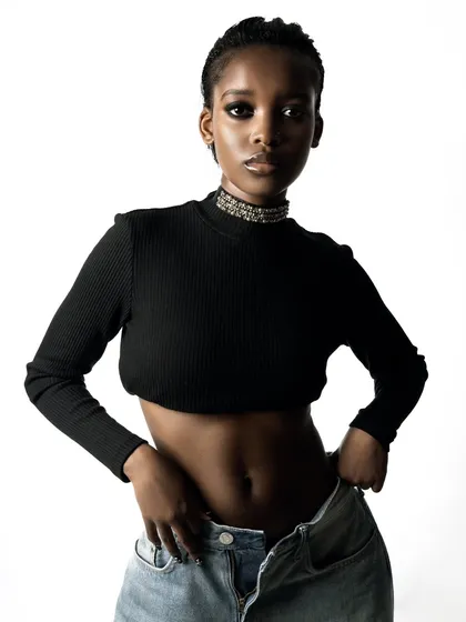A confident studio portrait against a clean white background. This high-contrast look is modern and powerful, perfect for a minimalist fashion brand's e-commerce site.