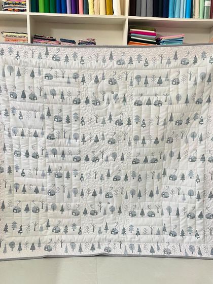 The back of the personalized "Skylar" baby quilt, showing a simple and modern camping-themed fabric.