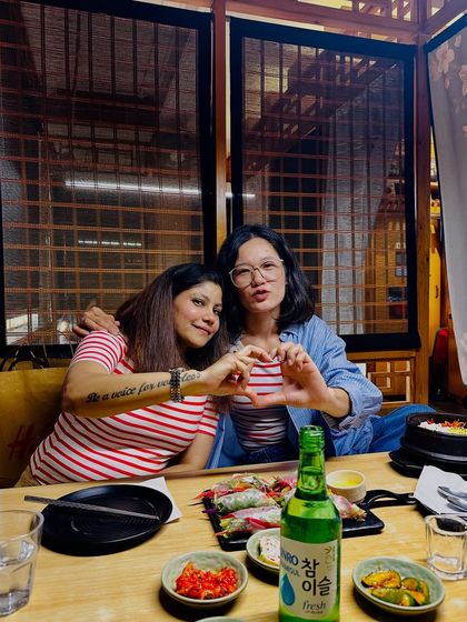 Enjoying an authentic Korean meal with friends. These moments showcase the social and communal aspect of Korean dining culture, featuring a table full of classic dishes and, of course, soju.