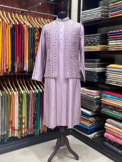 Meticulous craftsmanship in menswear. Displayed in our store, this lavender silk kurta and jacket set features fine pintucks and subtle embroidery, representing our custom tailoring service for grooms and festive occasions.