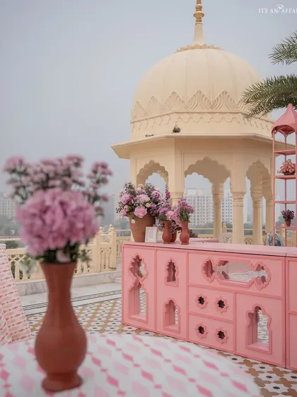 The custom-designed pink bar, with its intricate cutouts, stands against the backdrop of a traditional Rajasthani dome.