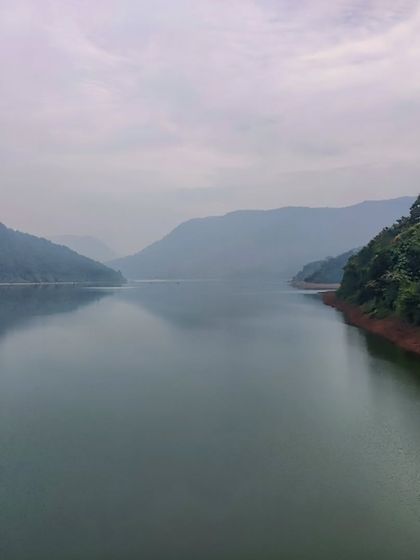 The calm, expansive waters of the Kali river reservoir, surrounded by the dense forests of the Western Ghats. This is the serene backdrop for our Dandeli cycling adventure.