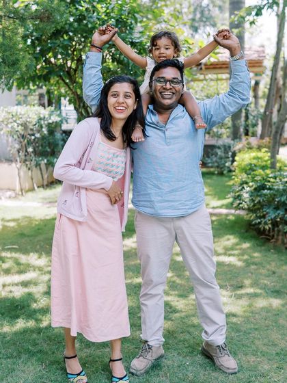 A family portrait full of laughter and joy. The daughter on her father's shoulders is a classic, happy pose.