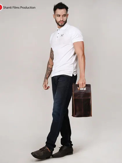 We capture accessories from multiple angles, as seen with this male model holding a leather utility bag. This helps highlight the product's handle and portability.