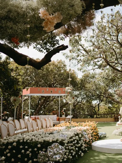 A view of the ceremony space from behind the floral aisle, showing the layers of decor from the hanging baby's breath to the lounge area in the distance.