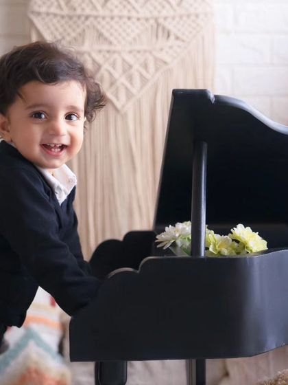 Such a charming little poser. This one-year-old boy in his smart black suit is a natural in front of the camera, full of smiles and personality.