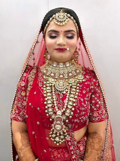 A full view of a bride wearing a layered Kundan necklace set. This rental jewellery provides a grand and complete look for any wedding ceremony.